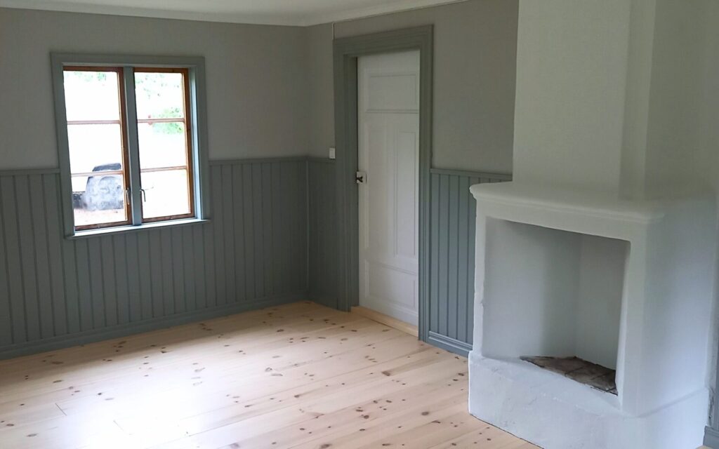 Renoverat rum med trägolv och kakelugn i Småland