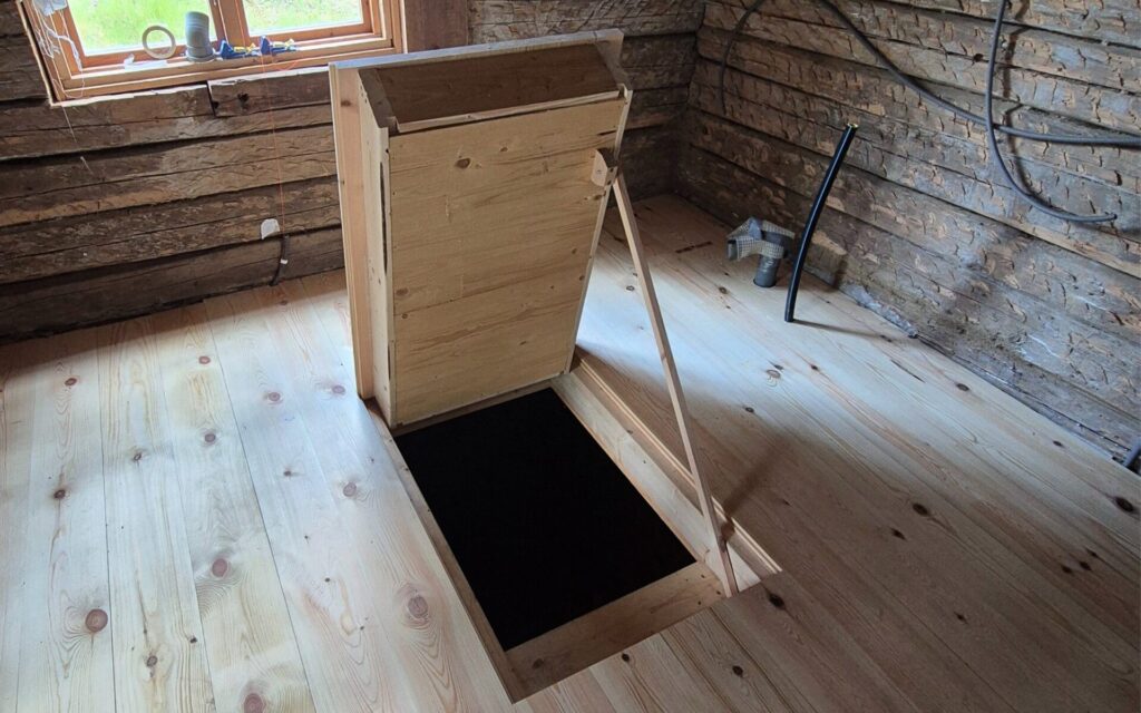 Individuell gefertigte Bodenluke aus Holz als Zugang zu einem Matkällare in einer renovierten Soldatenstuga.