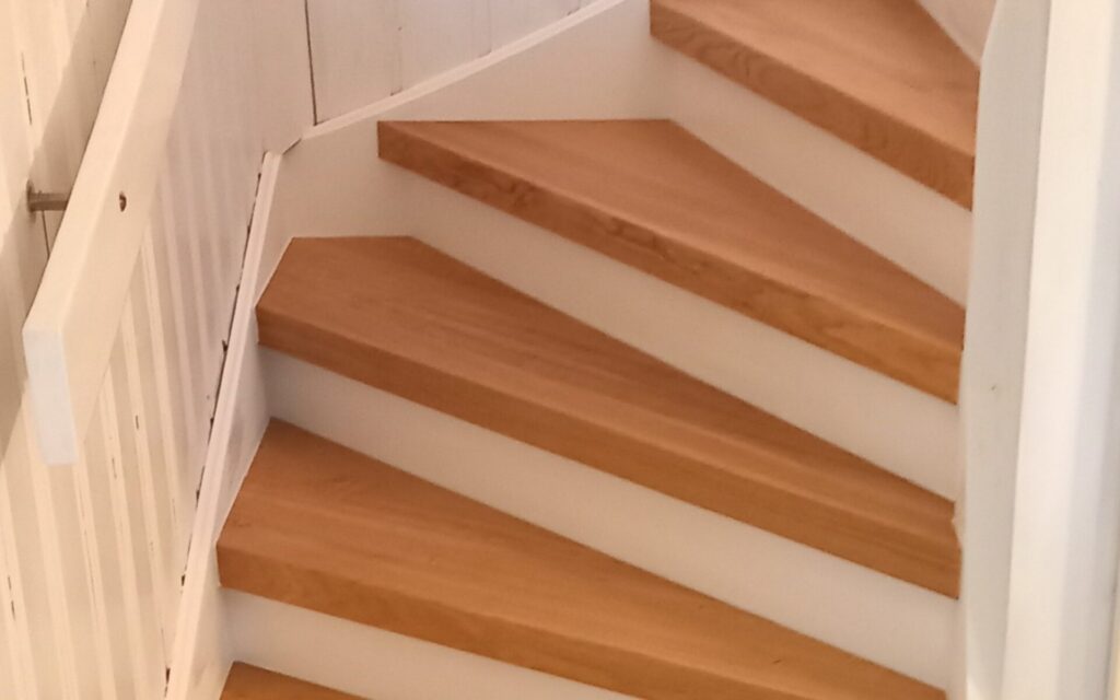 Måttanpassad trätrappa med vit vang och ljusa steg