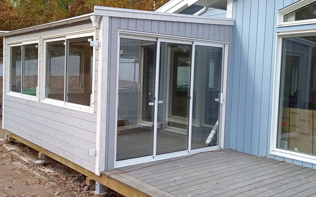 Kleiner Holz-Anbau mit großen Glasflächen in Vimmerby, angepasst an bestehendes Wohnhaus.
