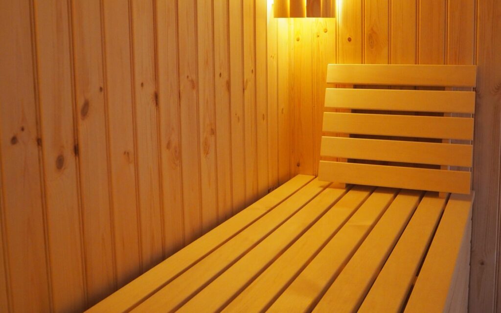 detail einer maßgefertigten holzsauna mit sitzbank und wandverkleidung aus massivholz